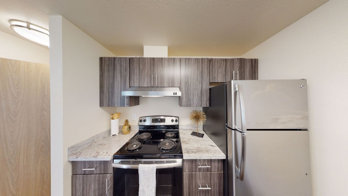 A kitchen with stainless steel appliances and wooden cabinets.