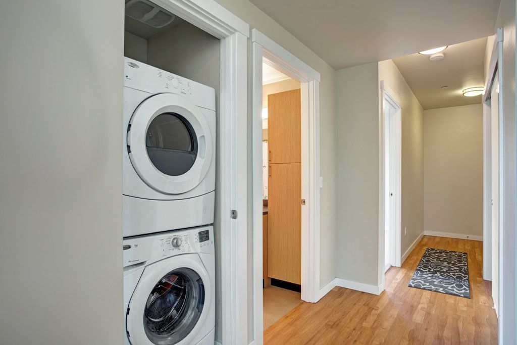A washer and dryer are stacked on top of each other in a hallway.