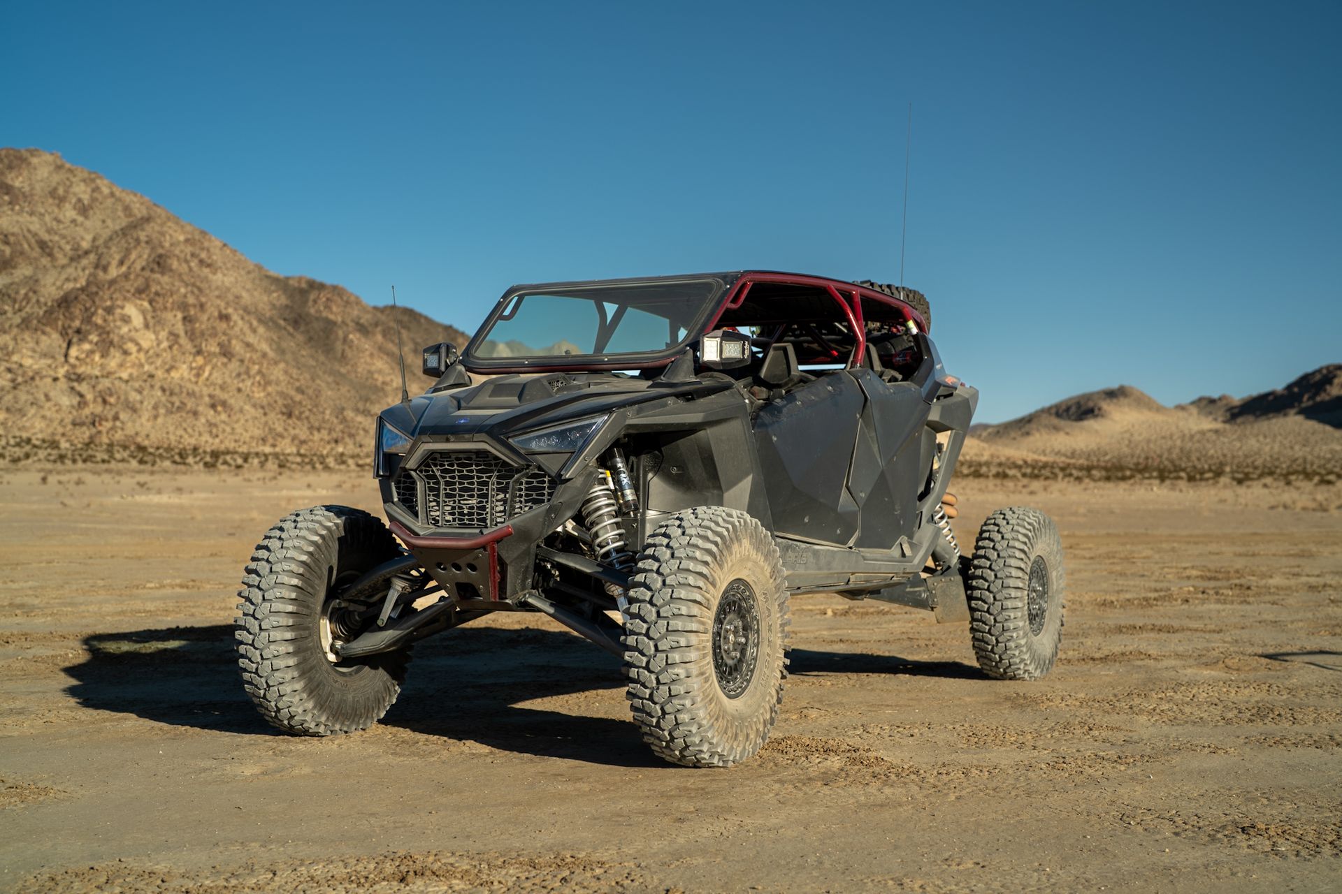 Off-road buggy with roll cage on a desert dirt track near rocky hills