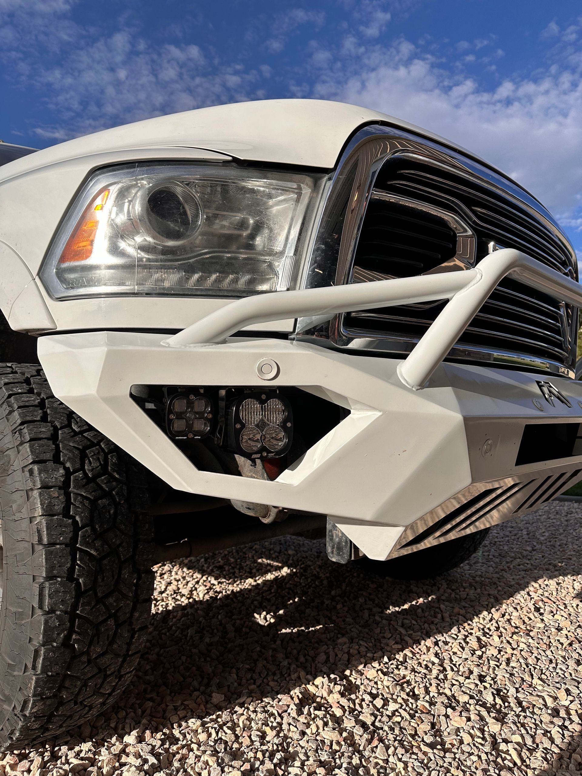 White off-road truck front bumper and headlight on gravel driveway