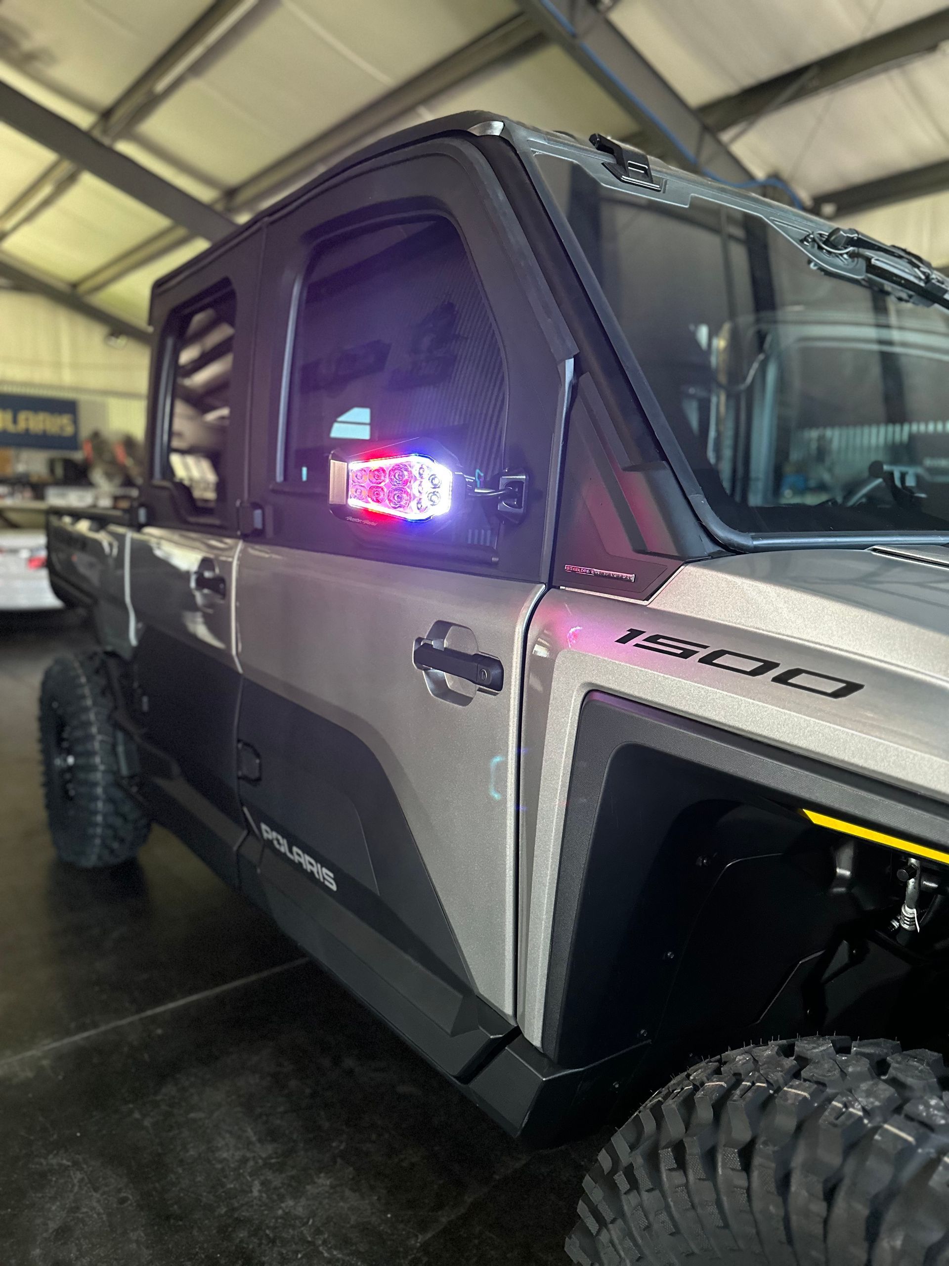Purple off-road truck in an indoor showroom, viewed from the front side.