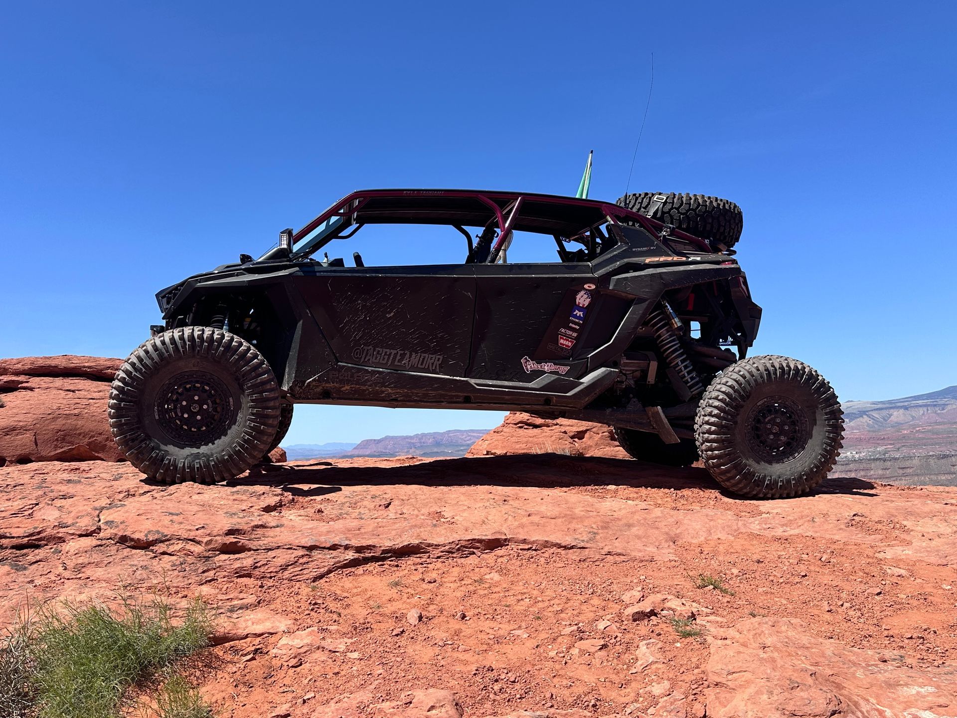 Off-road buggy on red desert rocks under a clear blue sky