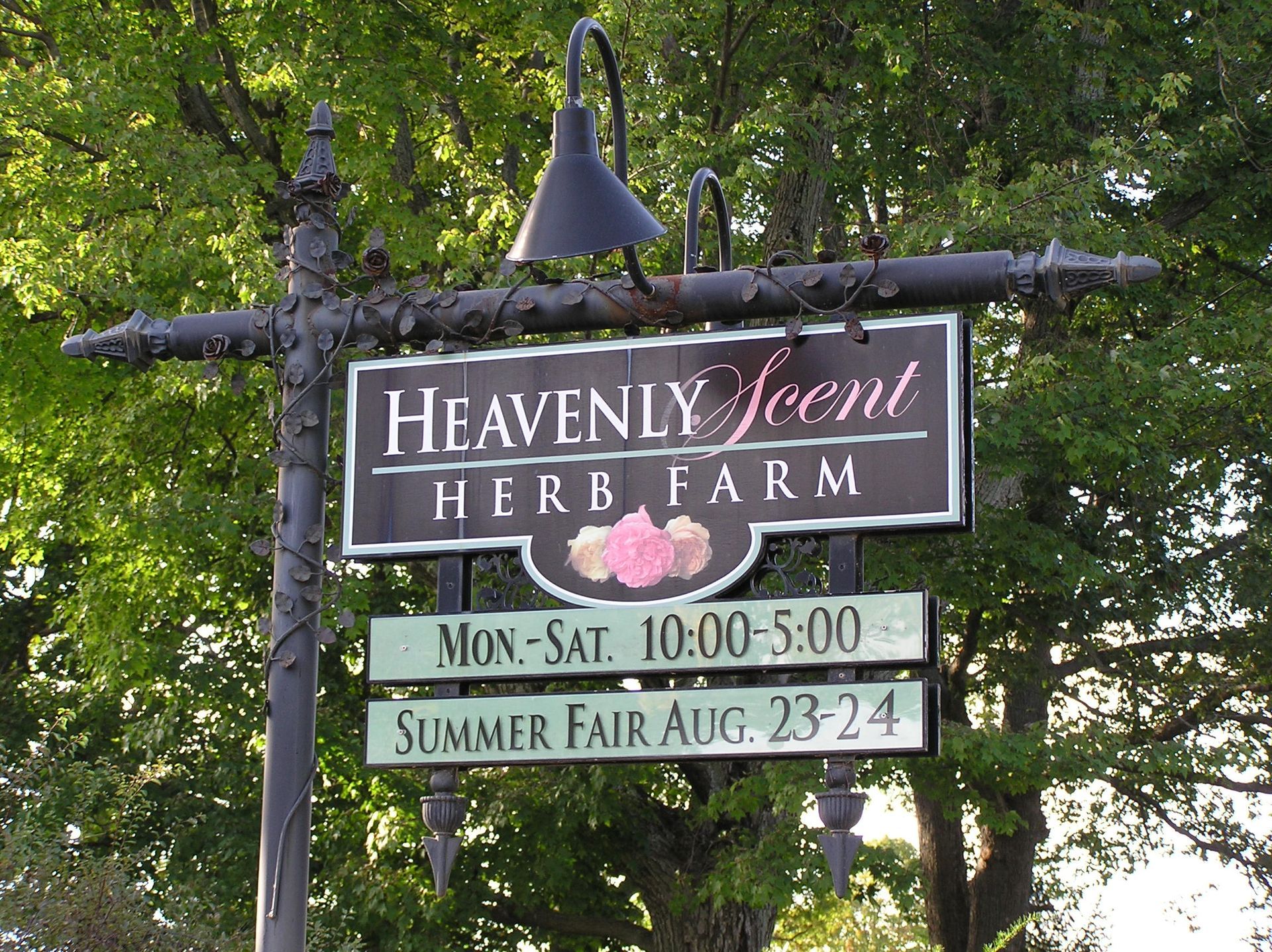 Sign for Heavenly Scent Herb Farm, with hours and summer fair dates.