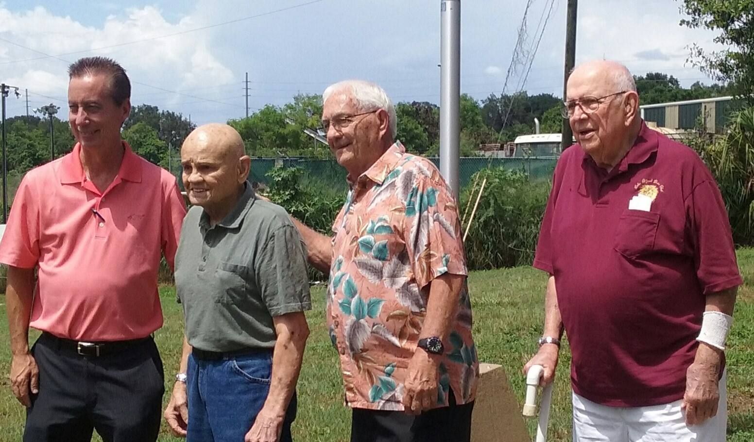 A group of men are standing in a grassy field