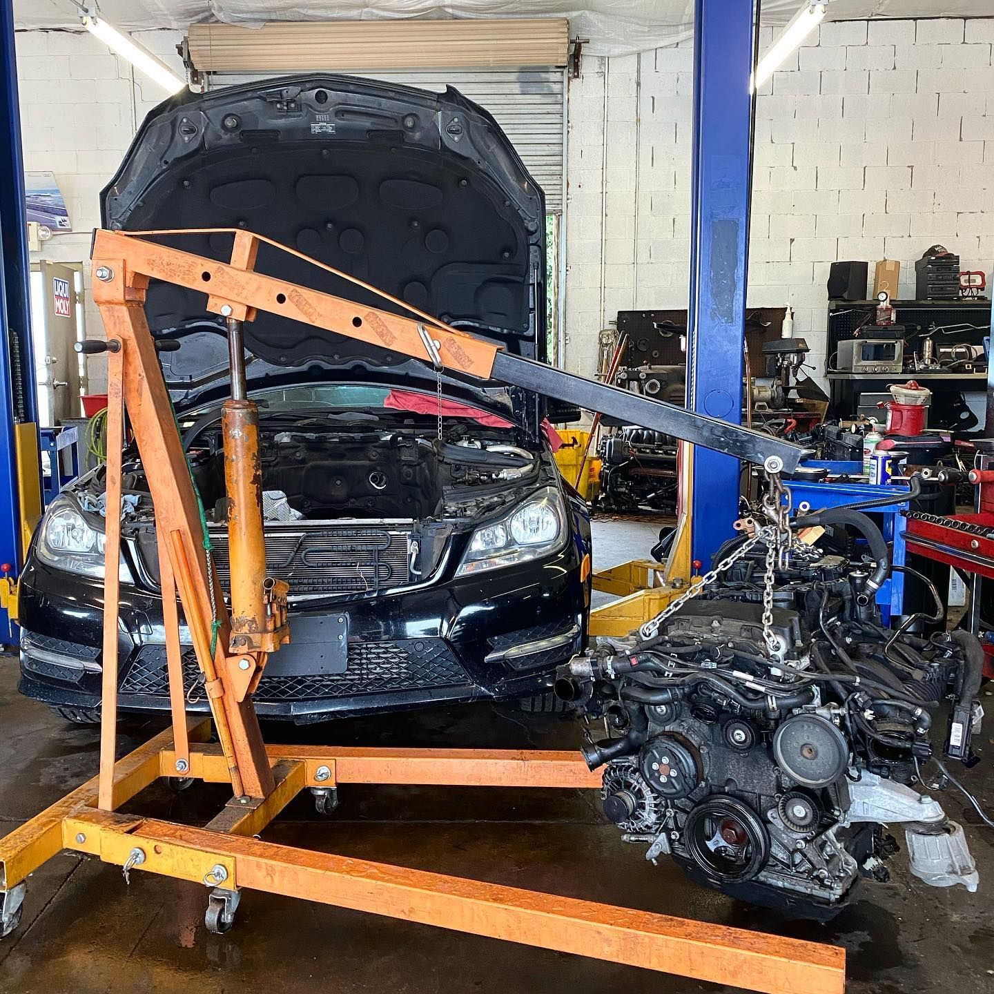Engine Hoisted By Orange Crane During Major Repair In Workshop | EurWerks