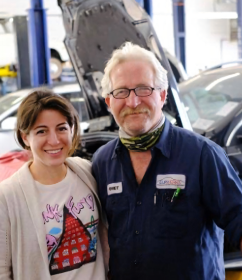 Smiling Auto Shop Owner Standing Beside Female Customer Inside Garage | EurWerks