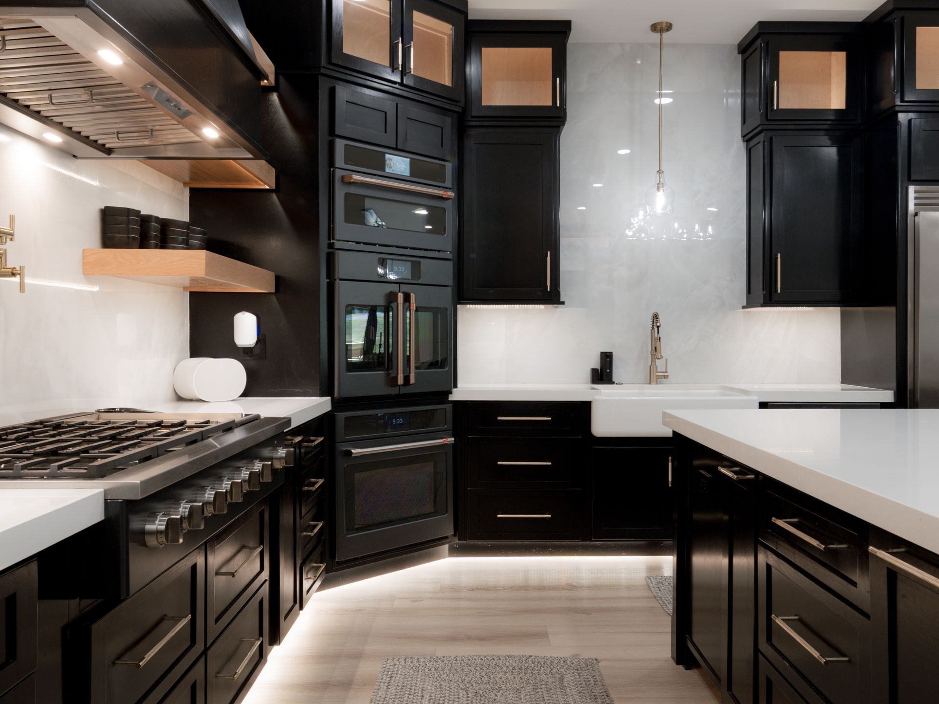 Modern black-and-white kitchen with marble backsplash, stainless stove, and large island