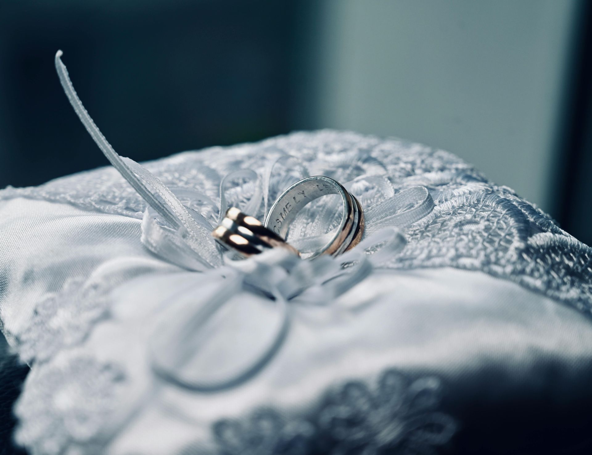 Two wedding rings resting on a white lace fabric