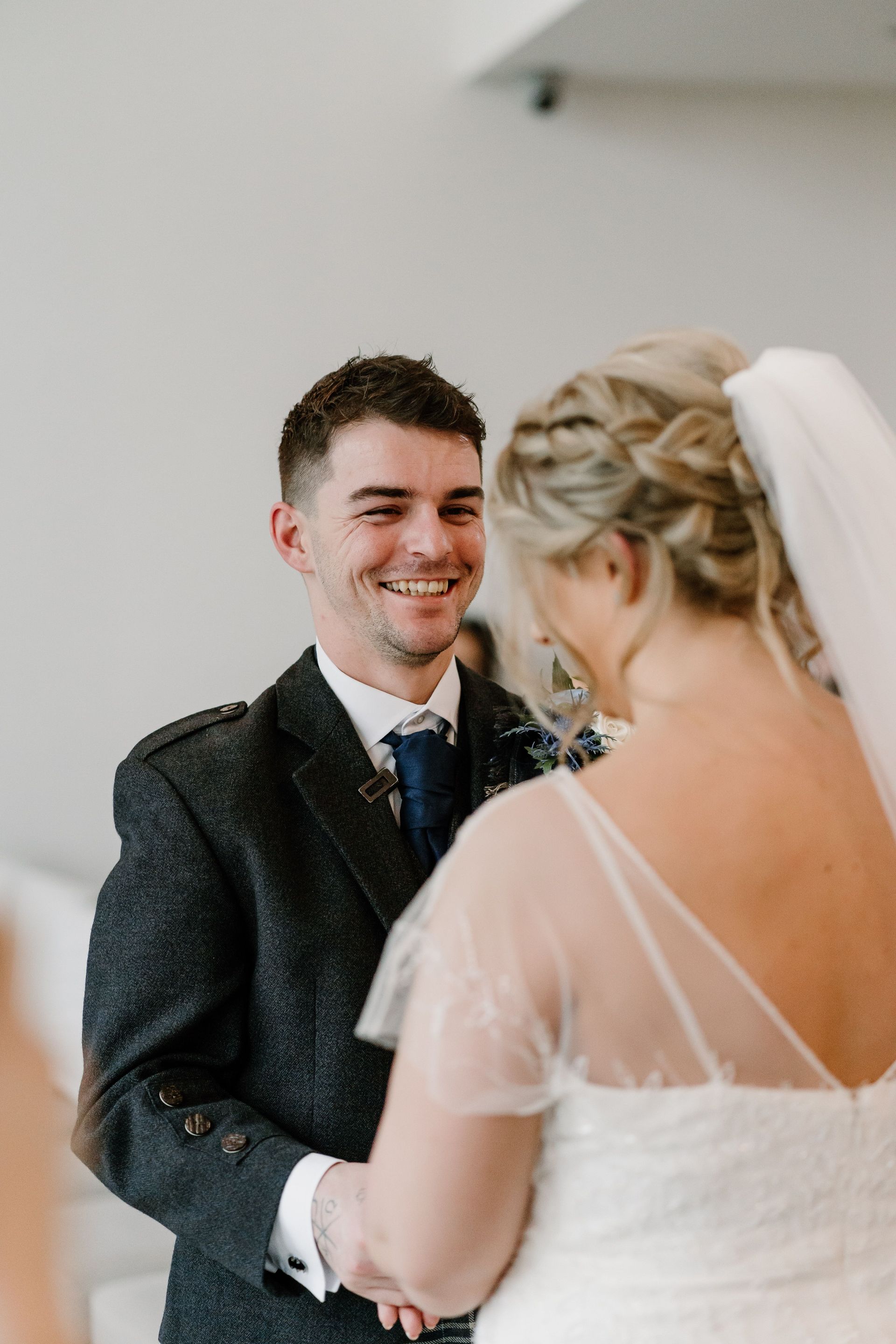 Bride and groom smiling during a wedding ceremony indoors