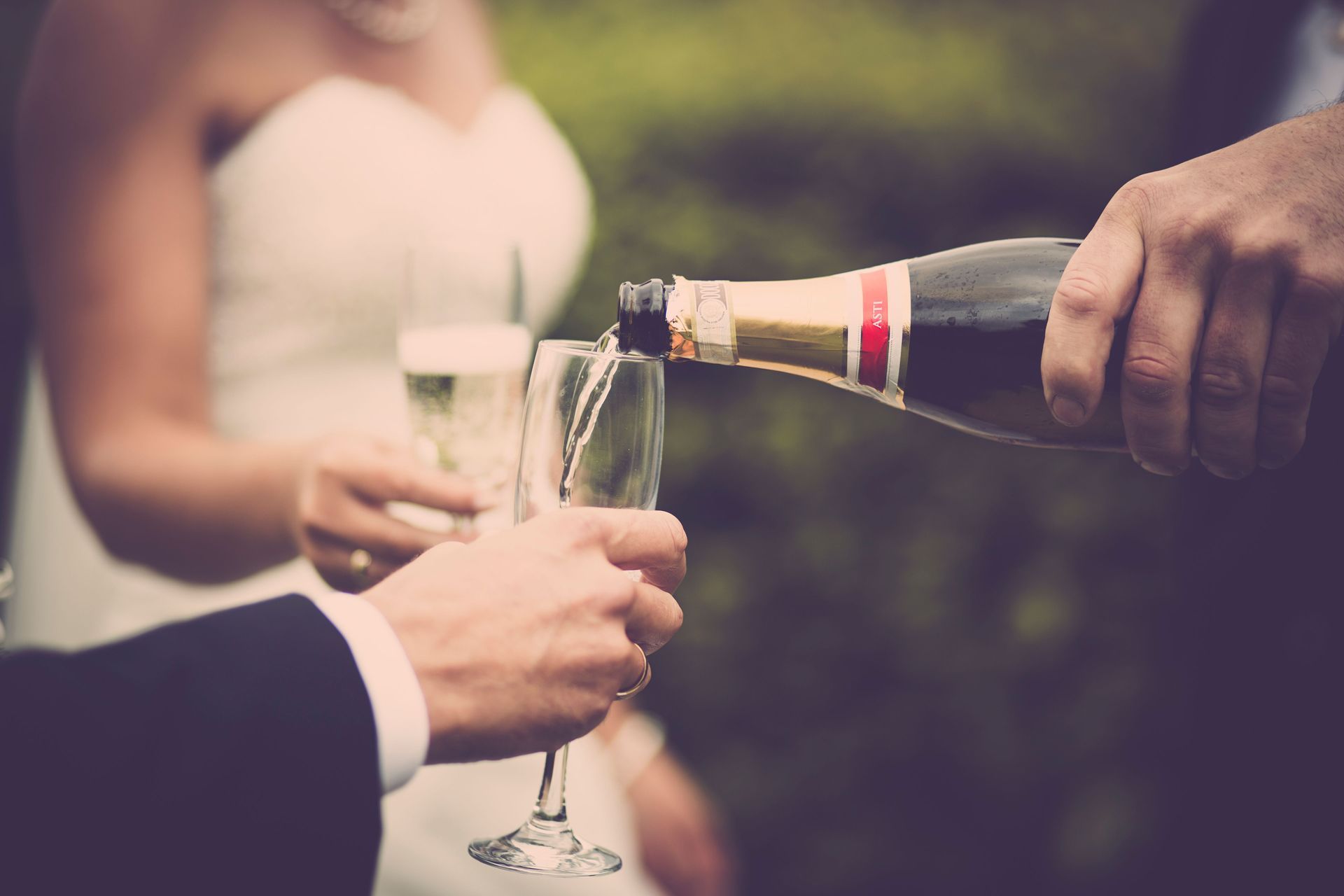 Champagne being poured into a flute at an outdoor celebration