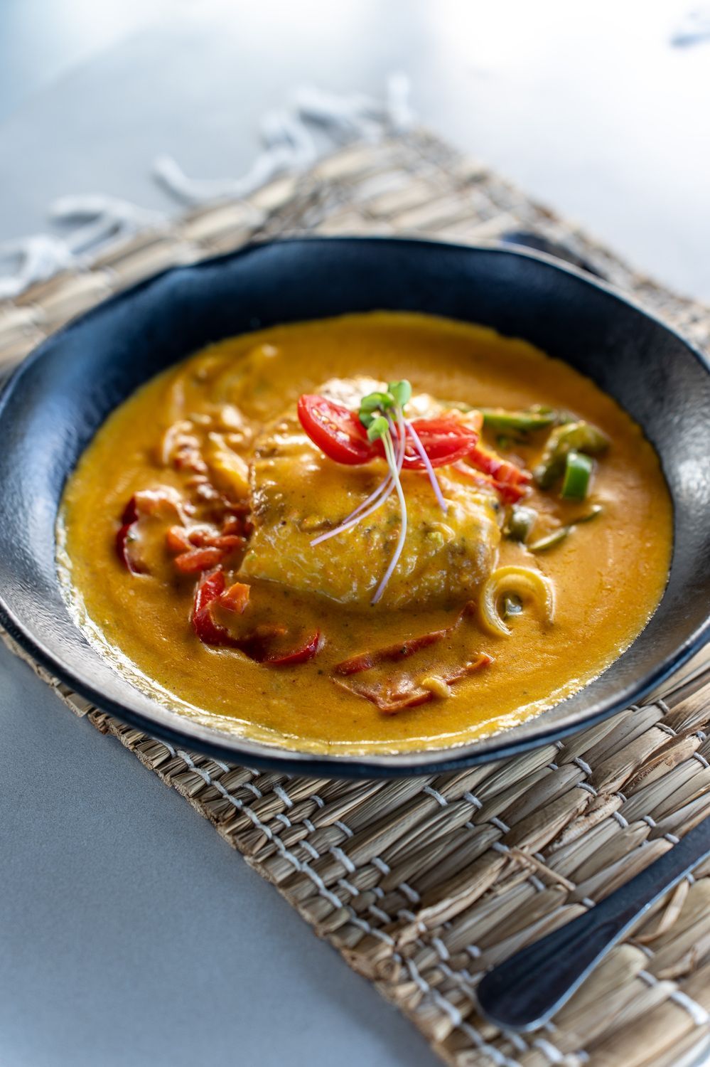 Um close de uma tigela de sopa sobre uma mesa.