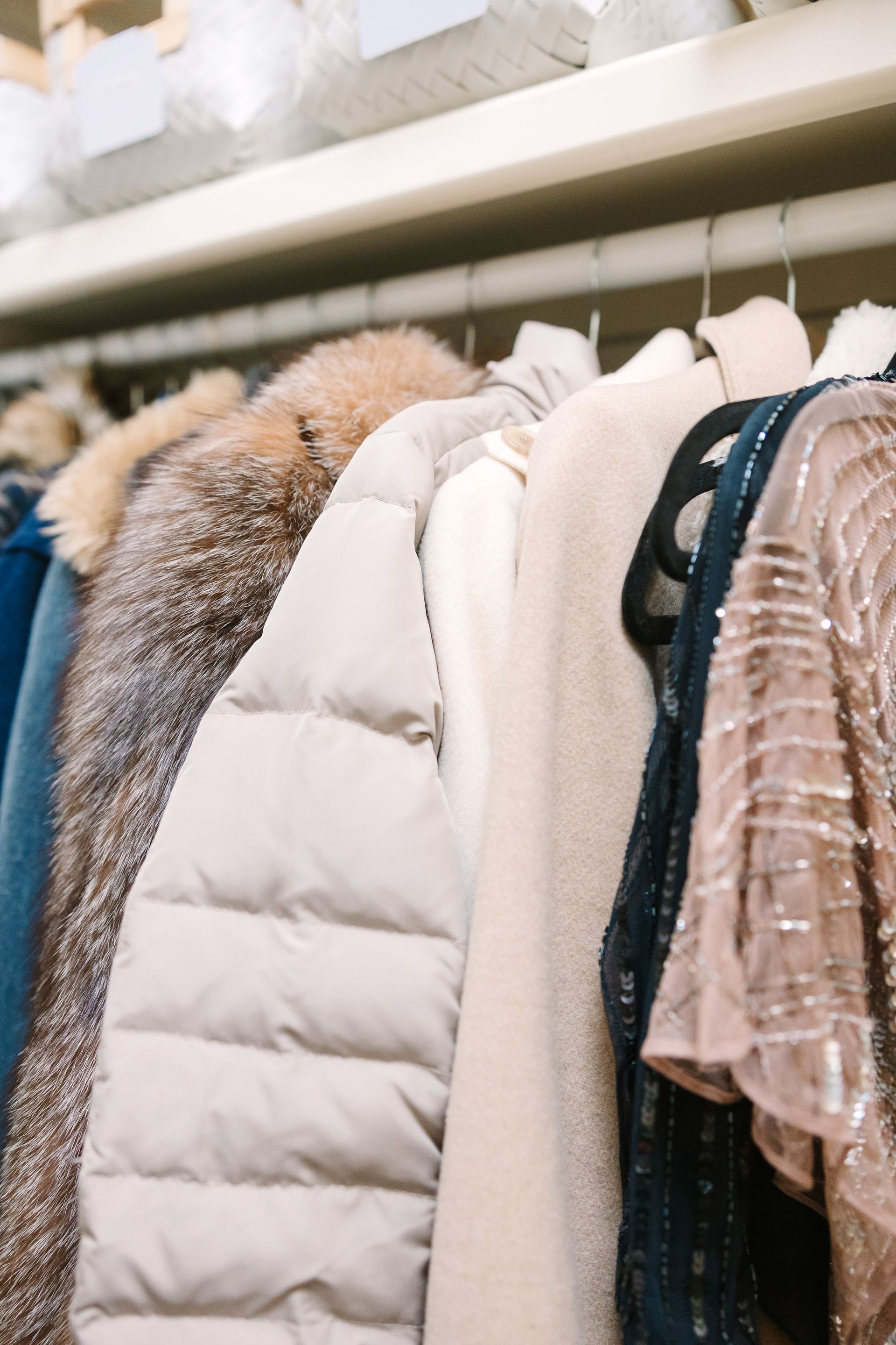 A closet filled with lots of clothes hanging on a rack.