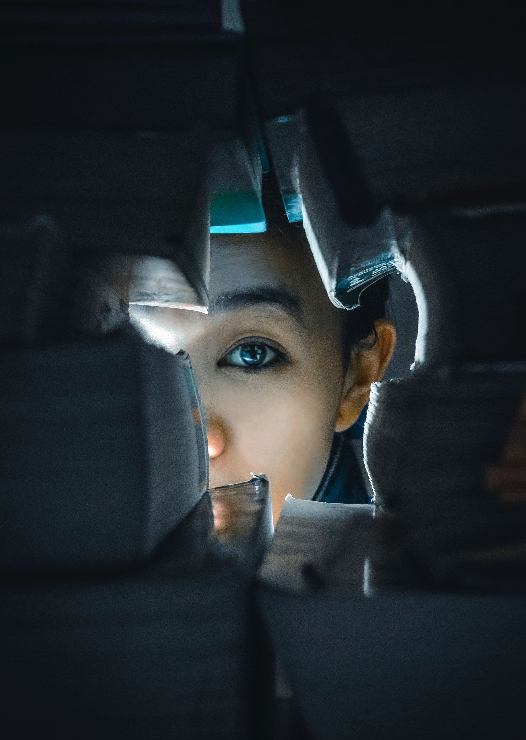 girl peeking through books