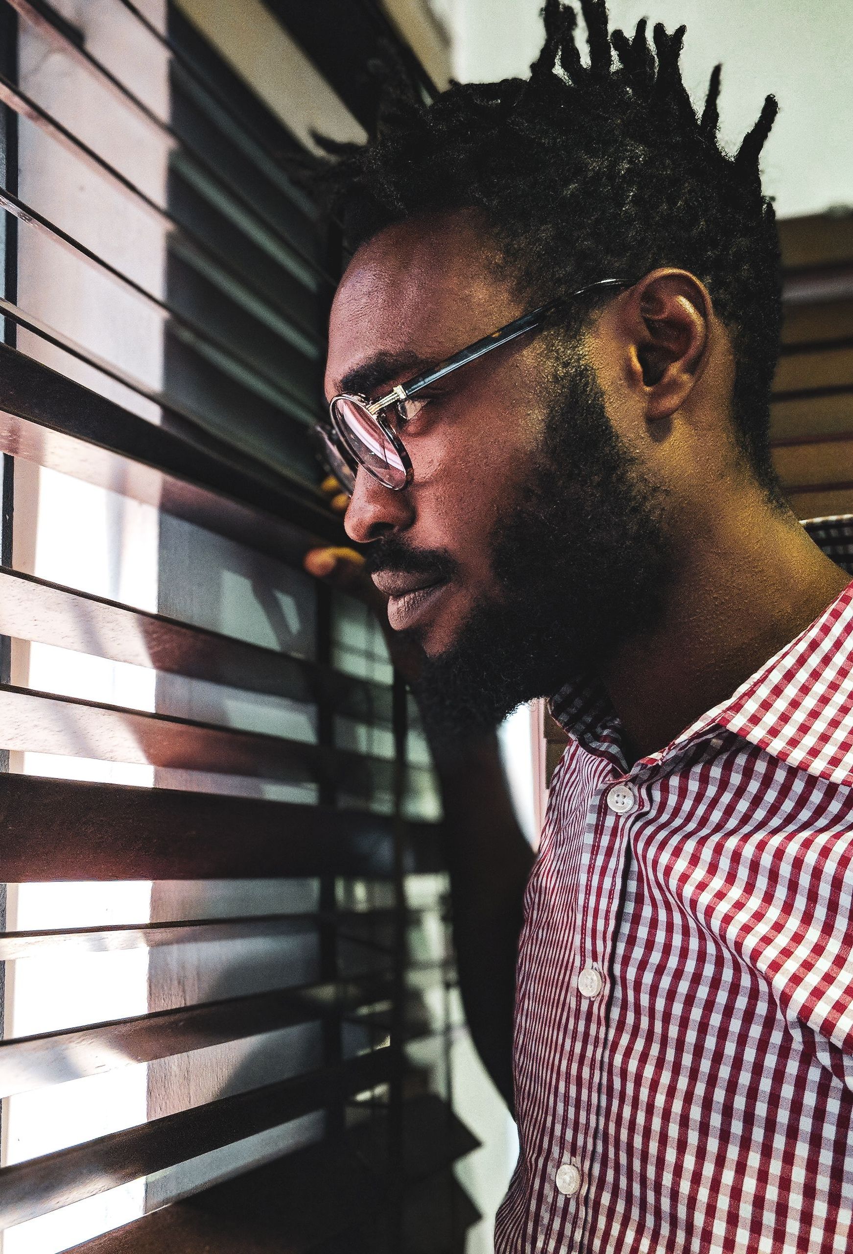 man in glasses looking out the window