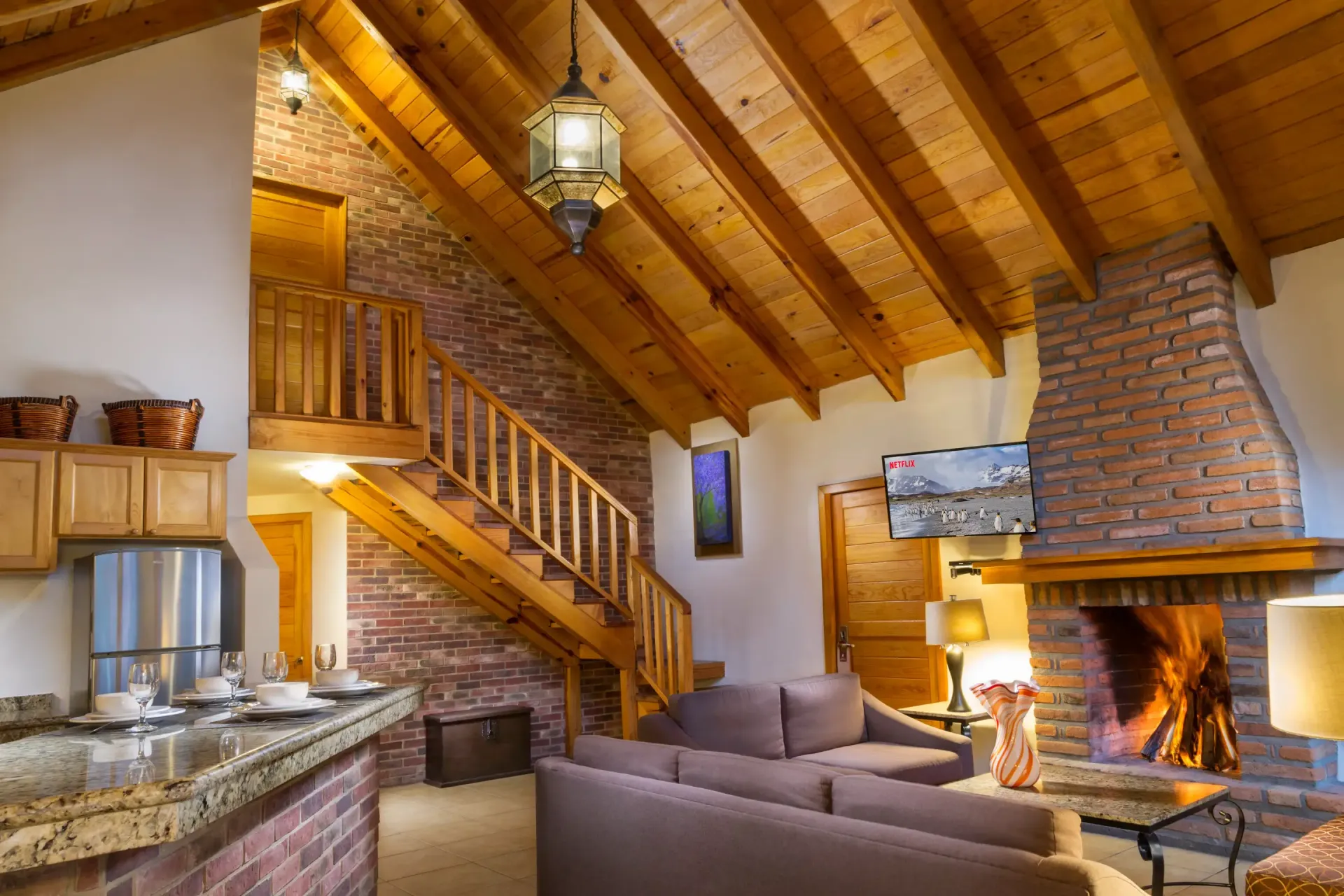 Una sala de estar con chimenea y escaleras.