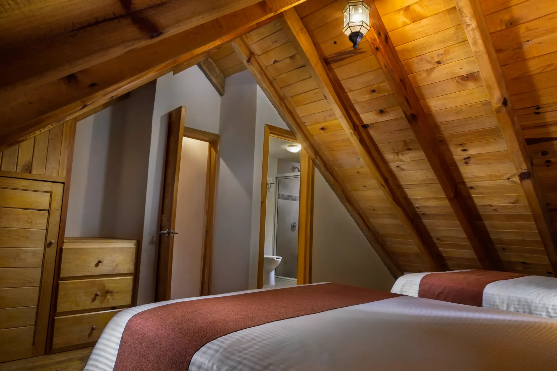 Un dormitorio con dos camas y techo de madera.