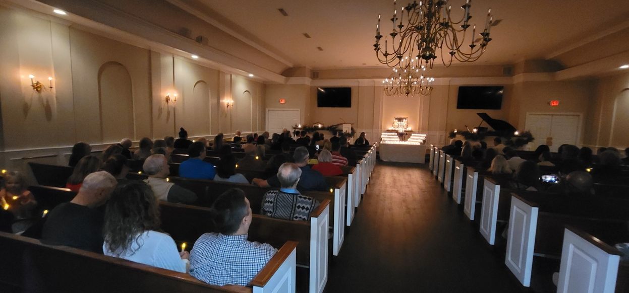 Audience seated in a banquet hall facing a speaker at the front