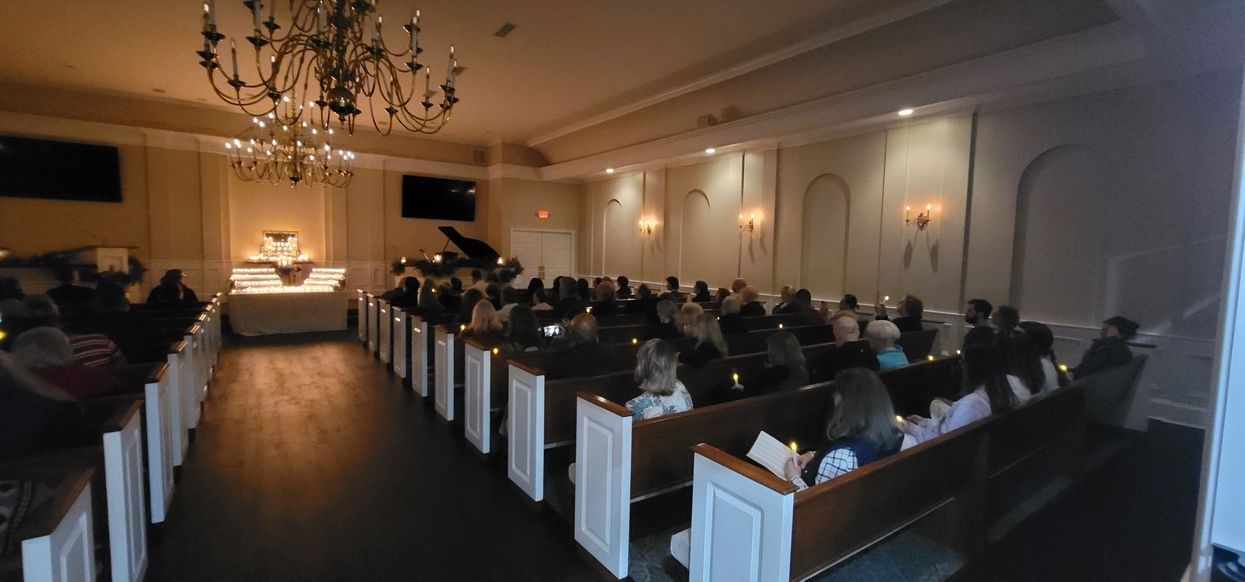 Dimly lit banquet hall with rows of seated guests facing a front stage