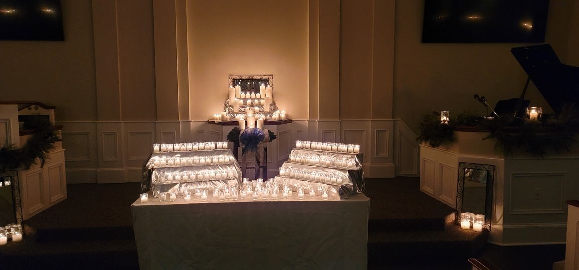 Candlelit altar with white flowers and steps in a dim church sanctuary