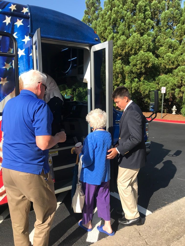 People boarding a blue star-decorated bus at an outdoor event