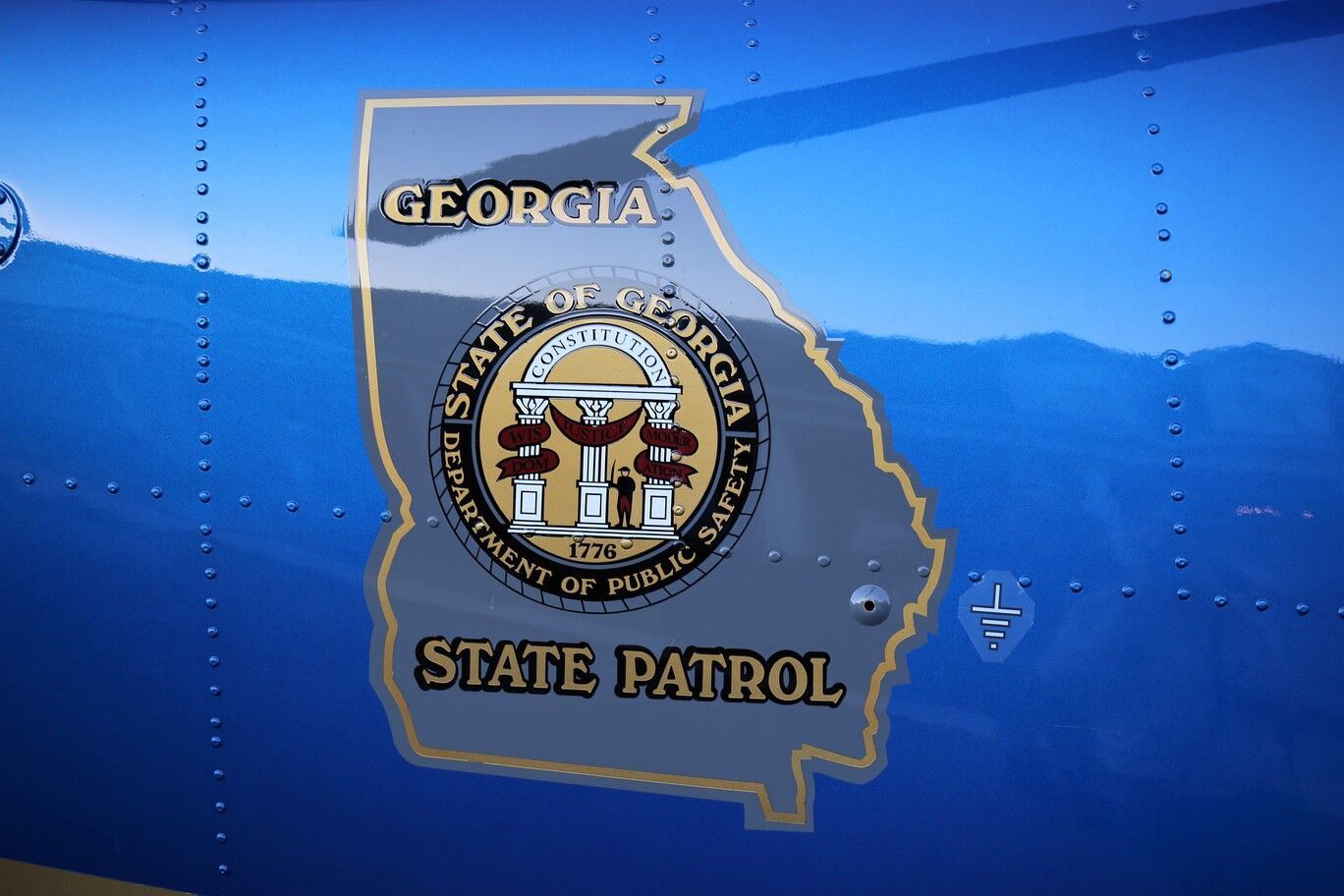 Georgia State Patrol emblem on the blue side of a patrol car