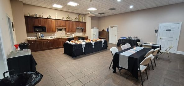 Banquet room with buffet tables, chairs, and a serving counter in a tiled hall
