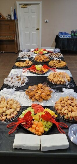 Buffet table with assorted appetizers and fruit platters in a banquet room