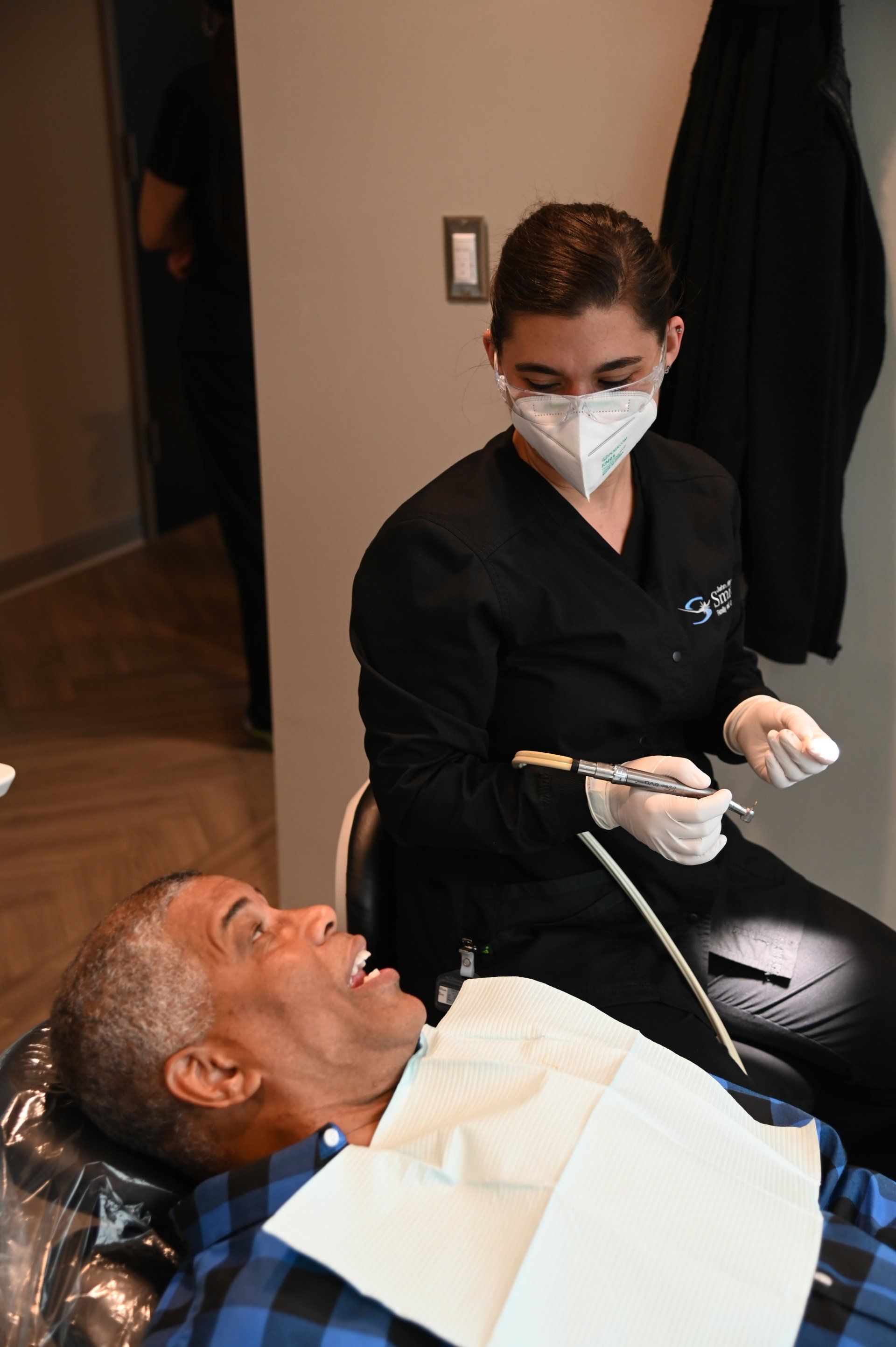 dental assistant examining a patient's teeth
