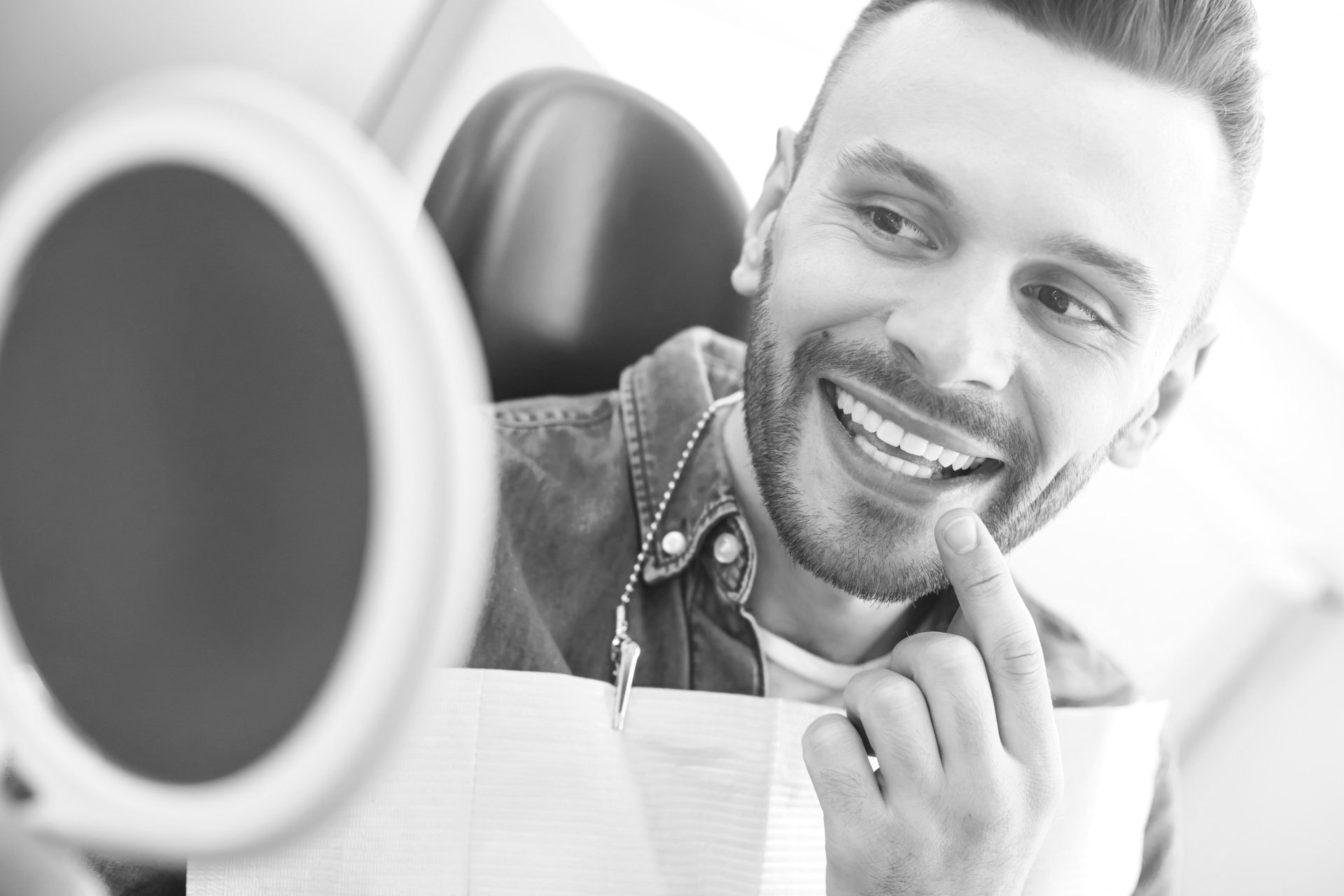 man admires teeth after dental cleaning