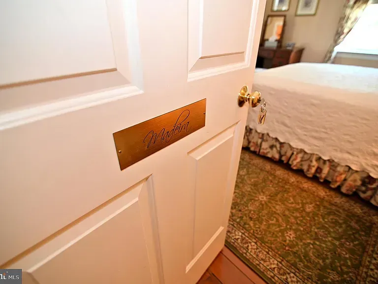 White door with gold nameplate "Martha", opened into a bedroom.
