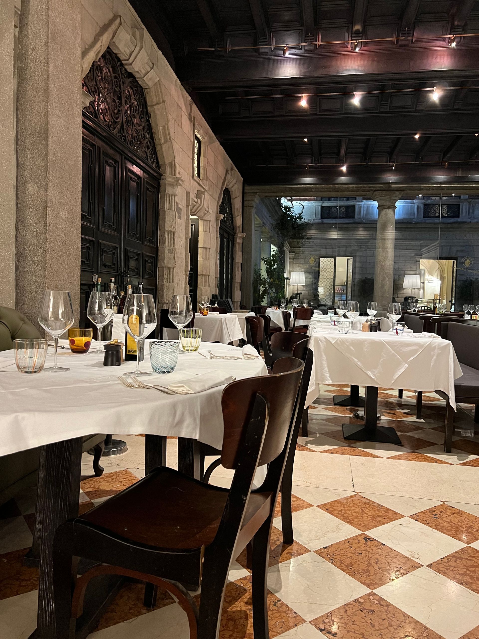 Un ristorante con tavoli e sedie e pavimento a scacchi.