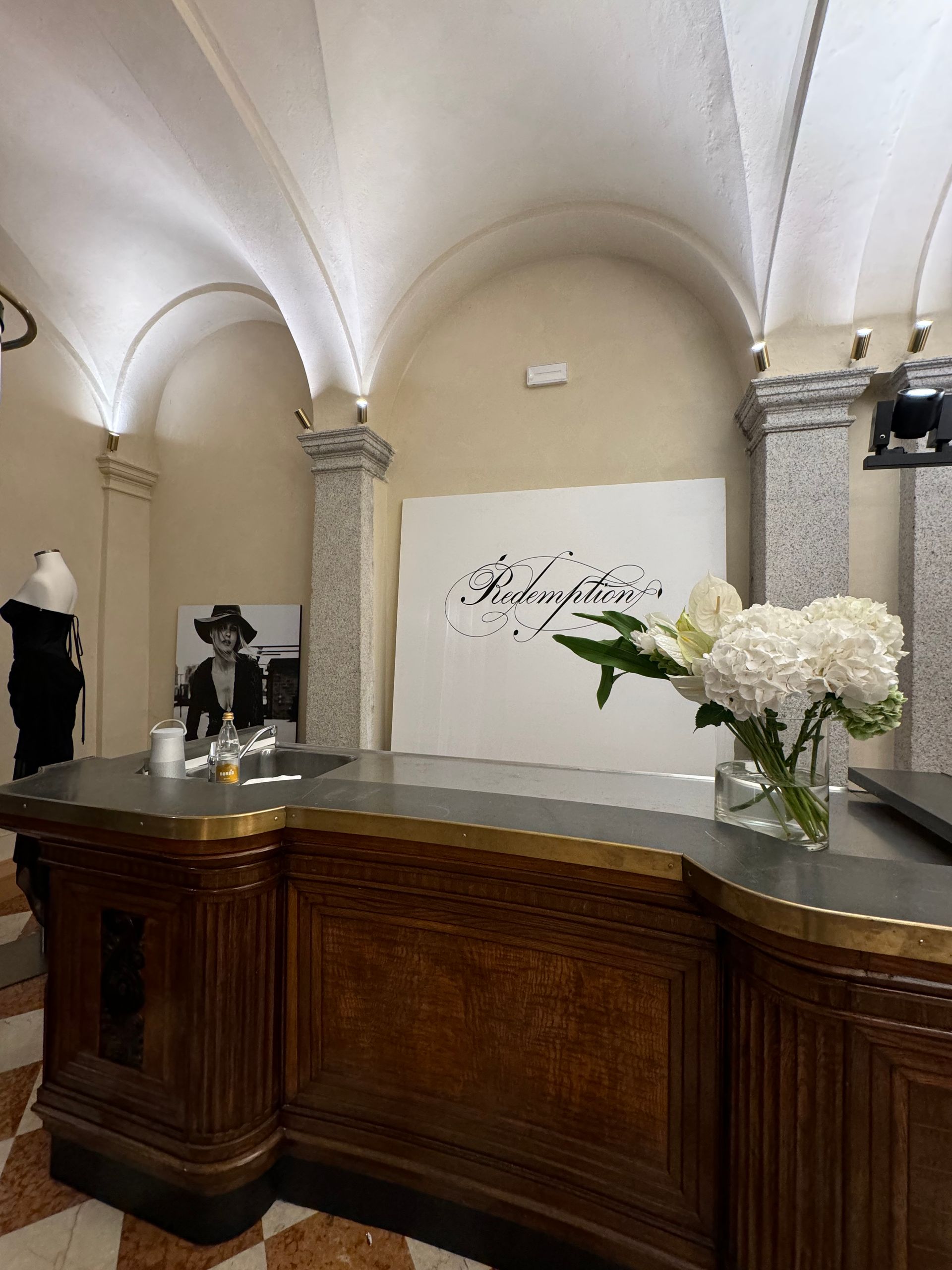 A reception desk with a vase of flowers on it