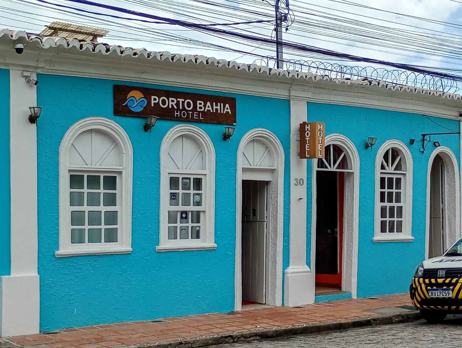 Prédio azul com detalhes em branco, placa
