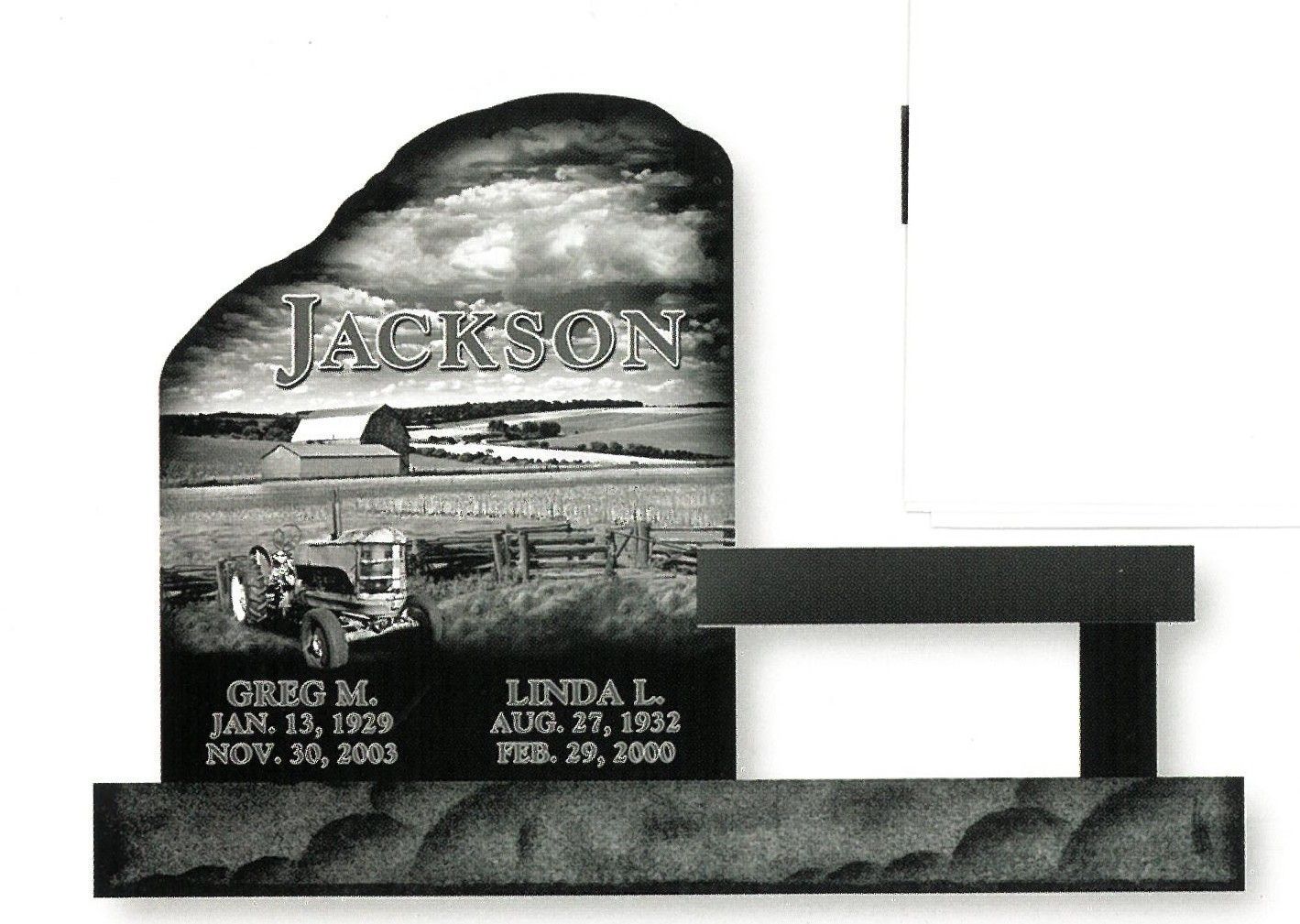 Jackson memorial gravestone with engraved landscape and bench-style base, showing two names and dates.