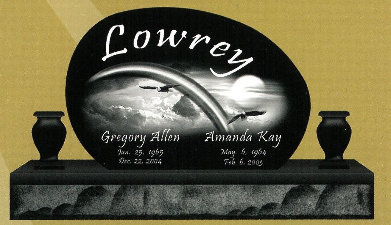 Black granite memorial plaque with engraved white dove and the name “Lowrey” in script.