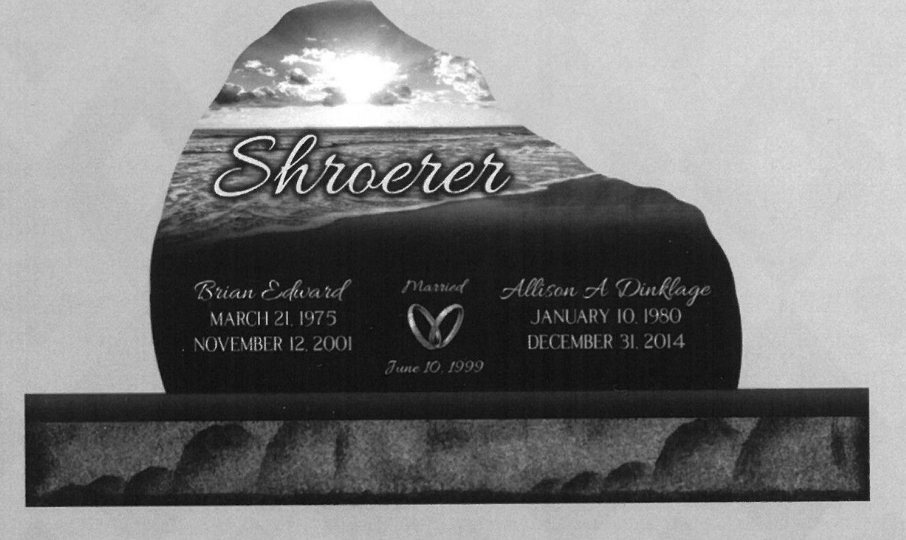 Black granite memorial headstone with engraved name and gold lettering on a rectangular base.