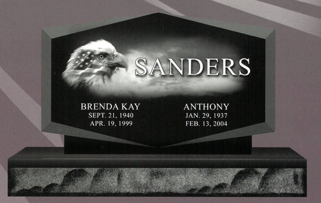 Gray gravestone with “SANDERS” and two name plates on a dark base against a plain background
