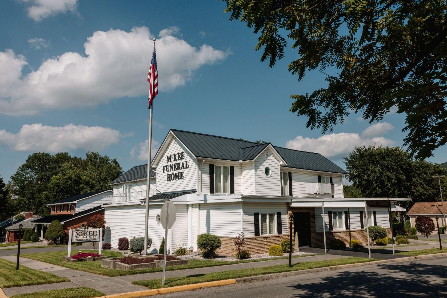 White building with an American flag and sign reading “Lions Club” on a sunny street corner