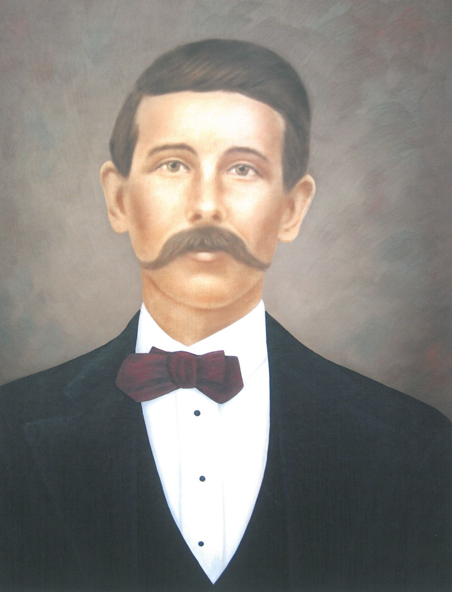 Formal portrait of a man in a dark suit, white shirt, and bow tie, with a mustache on a plain background