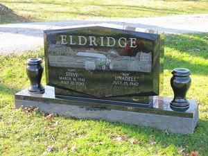 Eldridge family gravestone with black urns on either side in a grassy cemetery.
