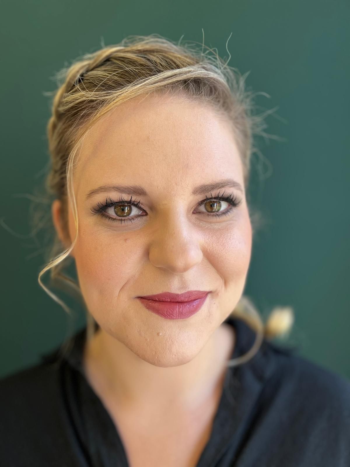 Eine Nahaufnahme des Gesichts einer Frau vor unscharfem Hintergrund.