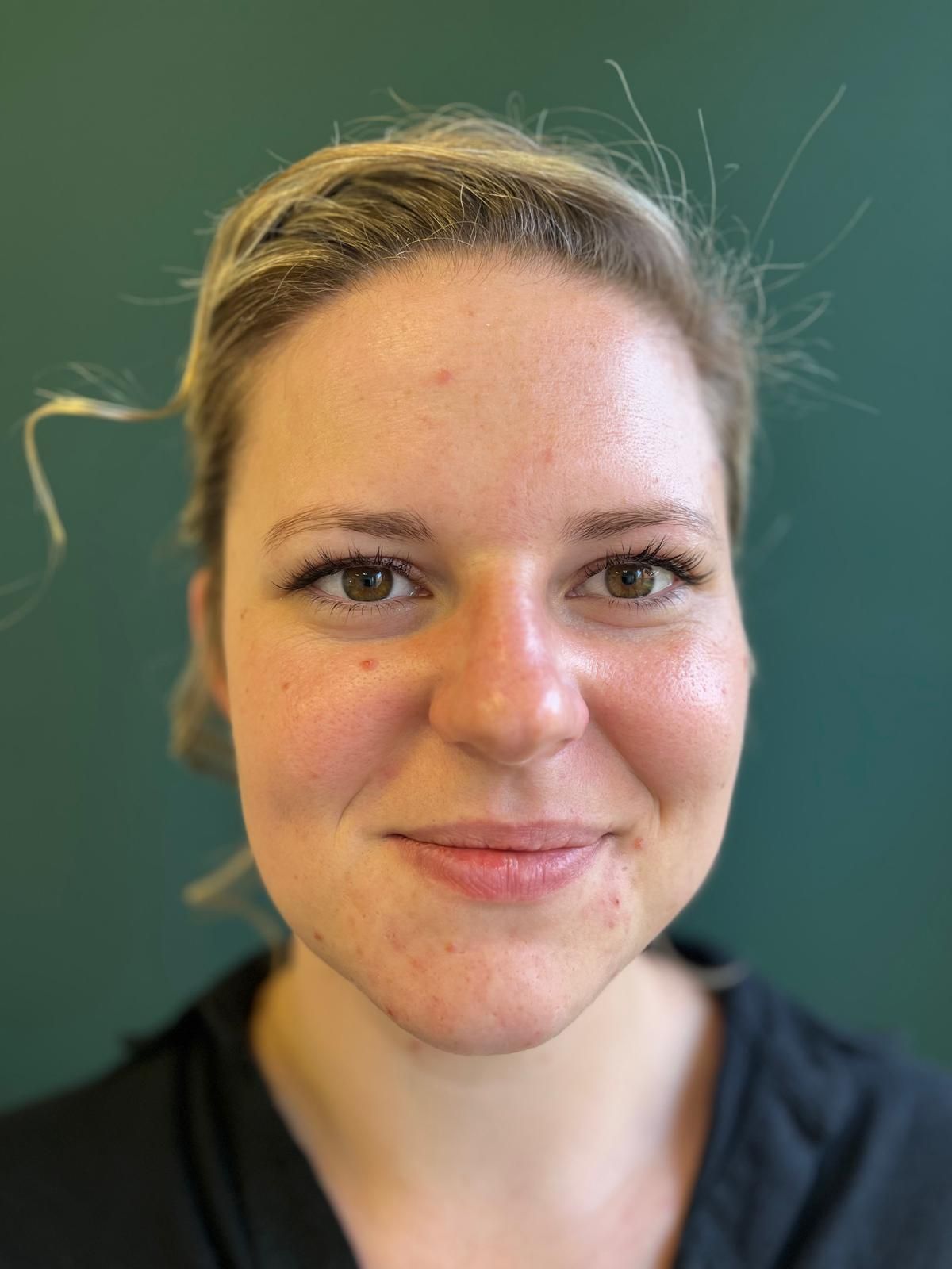Eine Nahaufnahme des Gesichts einer Frau vor unscharfem Hintergrund.