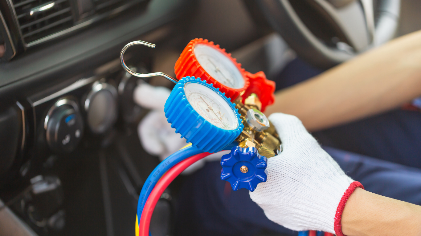 Gloved hands holding colorful car air vent clips near a vehicle dashboard
