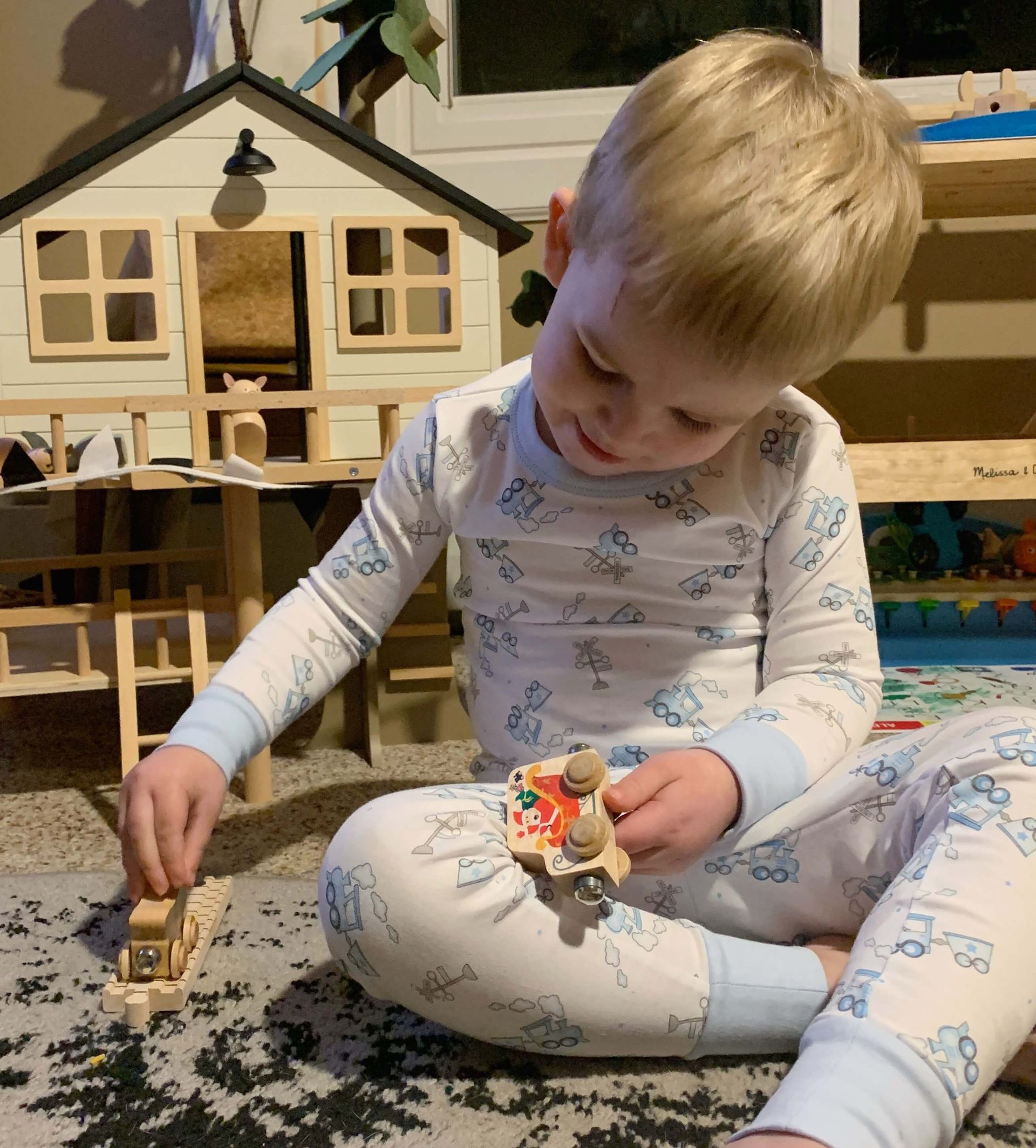 A little boy is sitting on the floor playing with toys