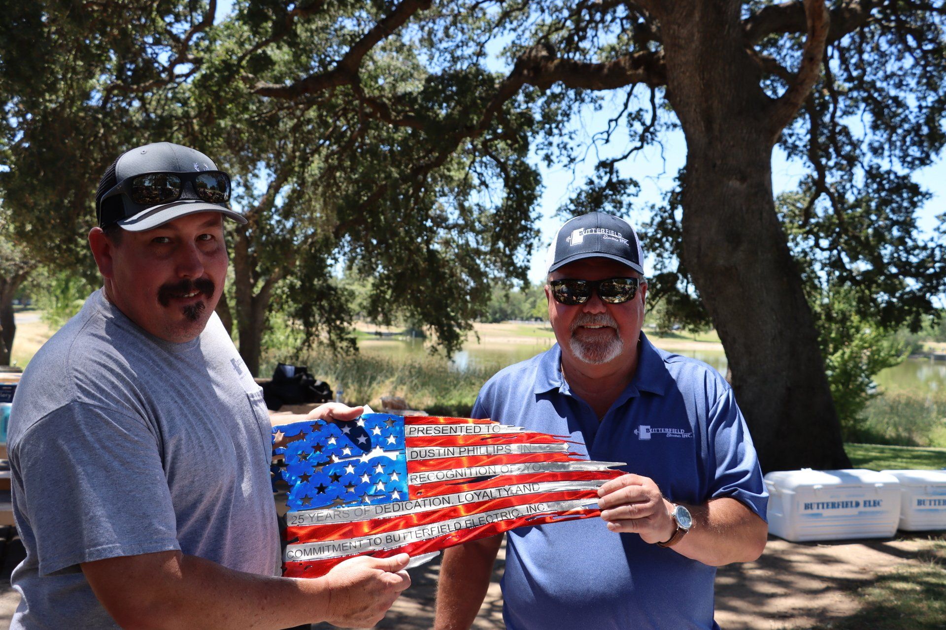 Two men standing next to each other holding an american flag
