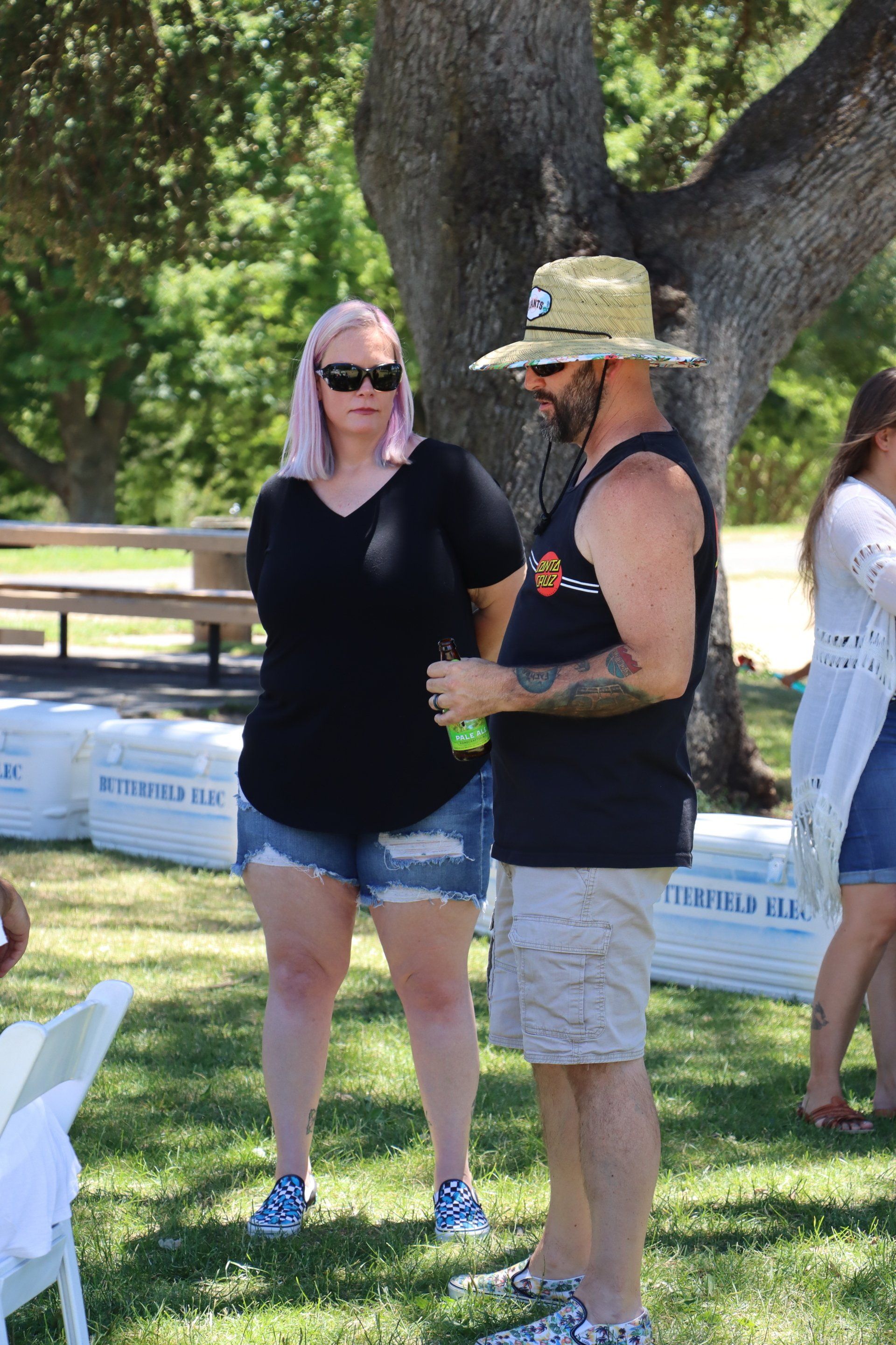A man and a woman are standing next to each other in a park.