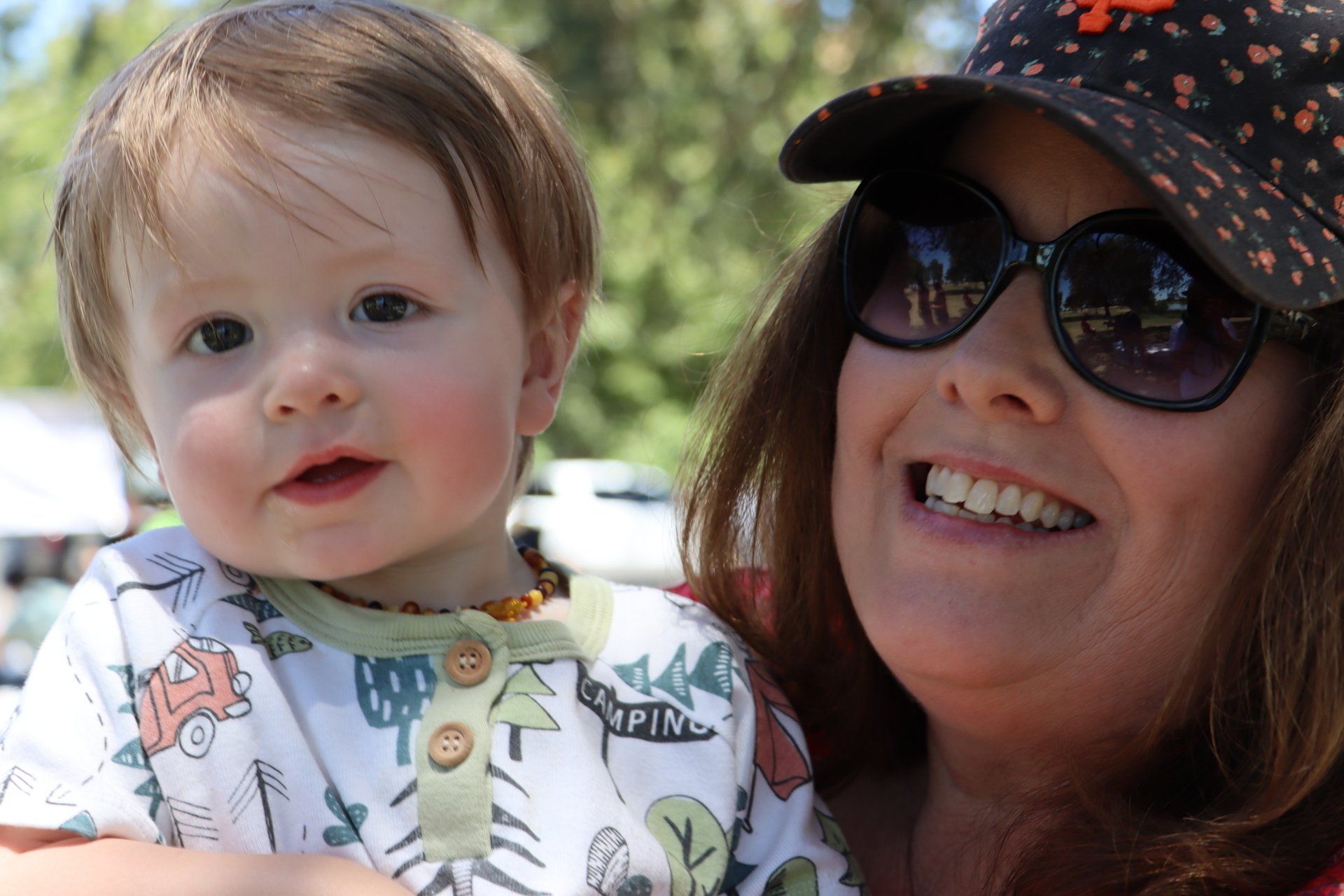 A woman is holding a baby in her arms and smiling.