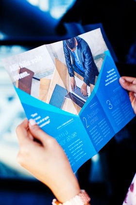 Hands Holding a Business Brochure