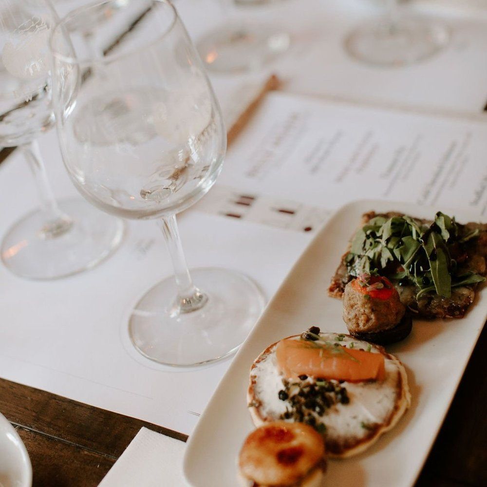 Wine glasses and food plate on a table at a wine tasting.