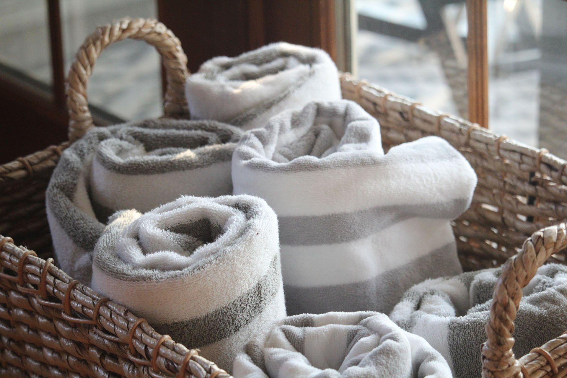 A wicker basket filled with rolled up towels